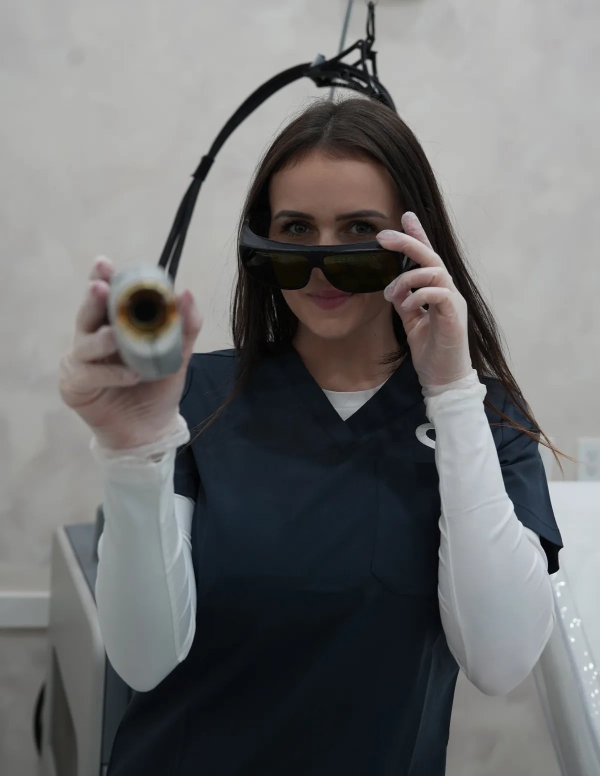 Semper specialist in protective goggles holding the laser handpiece